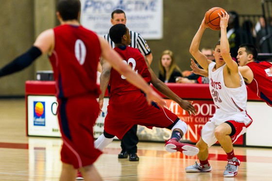 Freshman Brandon Kohler fights off SWOCC defenders in the Saints' first home loss since January on Saturday.
