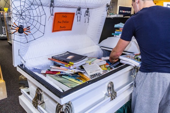 A student digs through the coffin of $1 textbooks in the Bookstore