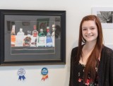 Emily Walker stands with her award winning painting last Thursday in the Visual Arts gallery. 