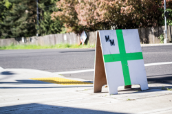 A sign depicting a green cross, that is the representation that a shop sells medical marijuana.