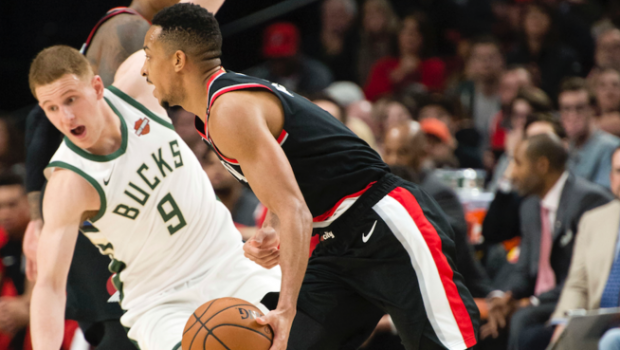 A photo of two basketball players on the court, one Bucks one Trailblazer.