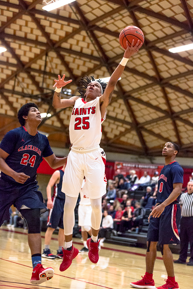 Kyler Haynes, MHCC men's basketball player, jumps for the hoop, surrounded by Clackamas players.