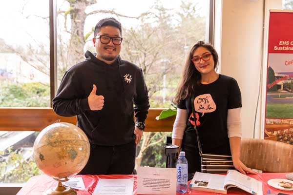 Photo of a man and woman smiling with a 3D globe for the geography club.