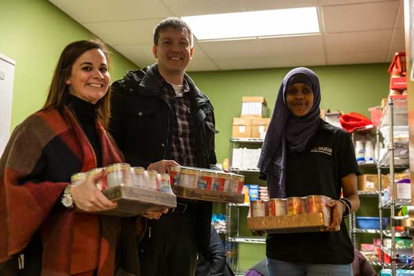 Photo of volunteers at Barney's Pantry stacking canned food items.