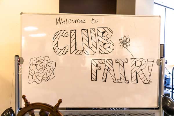 Photo of the whiteboard with words 'Welcome to the Club Fair.'