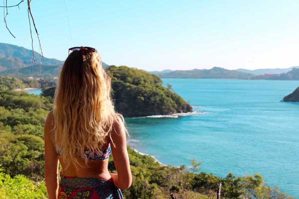 Photo of writer Sadie Klein look out over the Costa Rican lush, green lands and brilliant, blue waters on the coast.