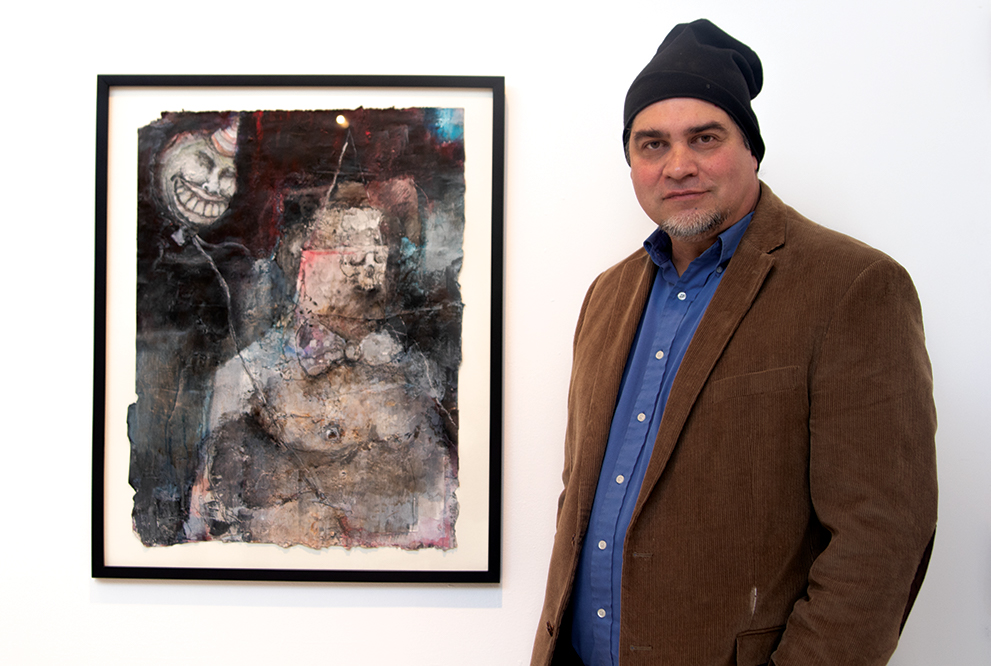 Artist Richard Chushall poses next to one of his air pieces