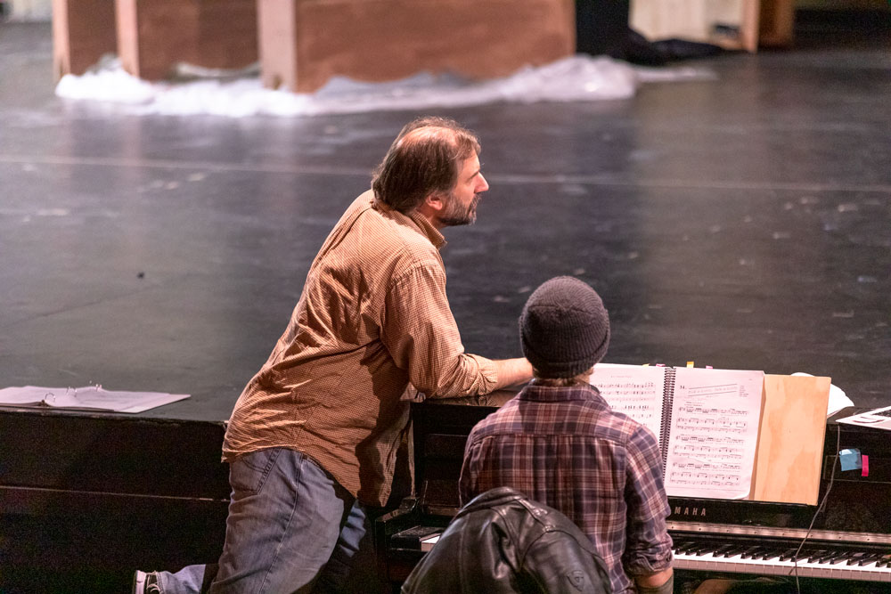 Photograph of director, Mace Archer, and pianist providing direction to performers.