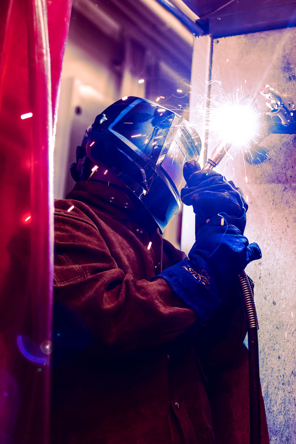 Photograph from the Welding Program, a day cohort student doing an overhead weld with flex core (FCAW) process.