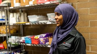Photo of Fardwosa Duale, ASG Campus Safety & Sustainability Representative helping stock the pantry after the acceptance of the Foundation donation on Jan. 24.