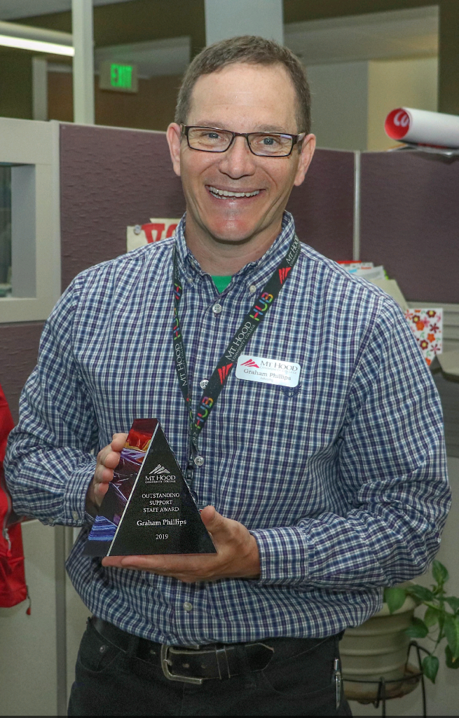 Graham Phillips holding his clear triangular Outstanding Support Award