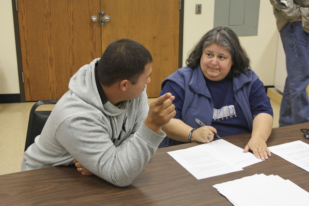 Valdivia working with a student at a table.