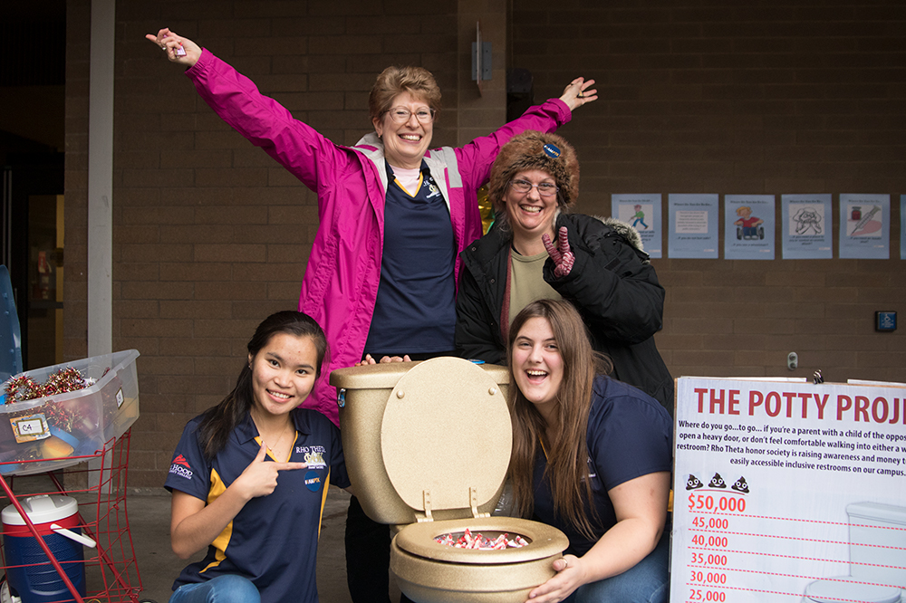 Rho Theta posing with golden toilet full of candy