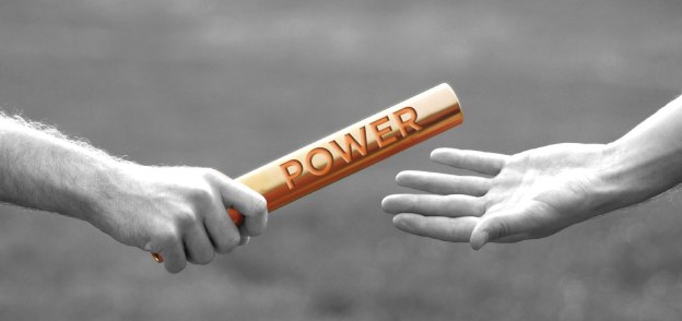 Baton engraved with the word Power being handed off, as during a relay